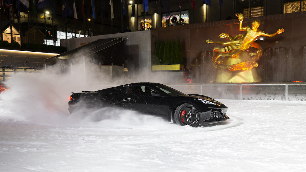 Profile view of 2024 Corvette E-Ray in Black performing maneuvers on The Rink at Rockefeller Center. Pre-production model shown. Actual production model may vary. Model year 2024 Corvette E-Ray available 2023.